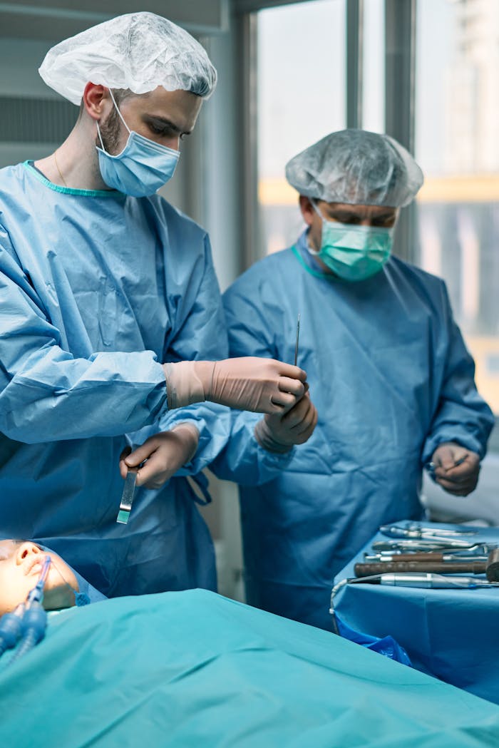 Two surgeons in an operating room performing a surgery under sterile conditions.